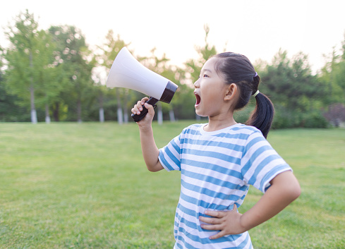 Photo image portrait of funny young attractive Asian man shouting with megaphone, happiness excited calling people promotion concept