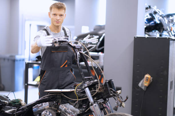 Auto mechanic checks technical condition of motorcycle in workshop