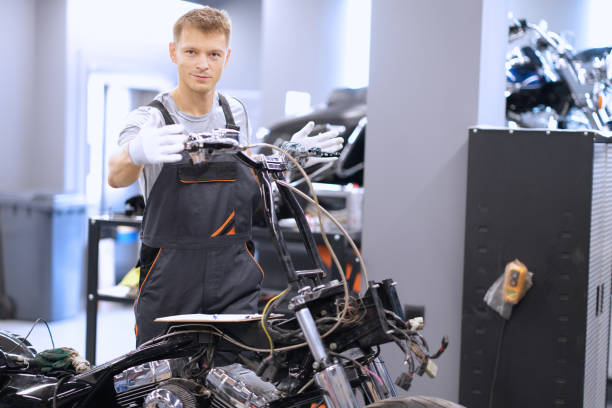 Auto mechanic checks technical condition of motorcycle in workshop Auto mechanic checks technical condition of motorcycle in workshop. Vehicle service station services concept technical routine stock pictures, royalty-free photos & images