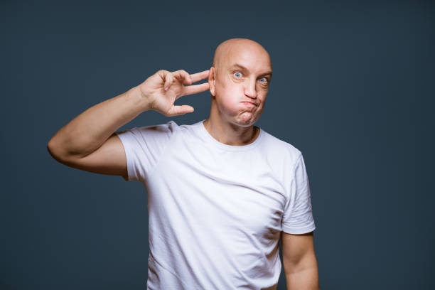 istock Comic bald-headed male posing on a blue background 1423021886