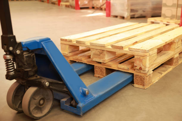 istock Modern manual forklift with wooden pallets in warehouse, closeup 1423021919