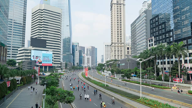 people exercise jogging , walking ,cycling along sudirman road at car free day on sunday morning in jakarta city, indonesia