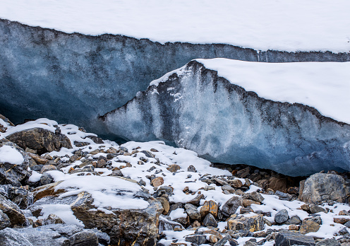 Glacier high in the mountains. A high layer of ice permafrost on a mountain peak. High quality photo.