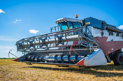 Agricultural machine for mowing wheat and other crops during the harvest. Combine harvester on a mowed wheat field