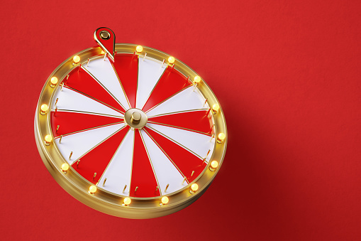 Wheel of fortune on red background. Horizontal composition with copy space. Front view.