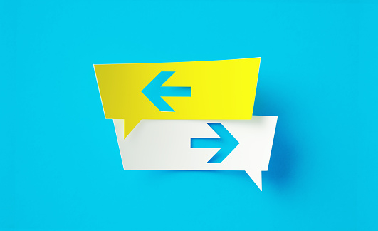 Yellow and white speech bubbles which are pointing opposite directions are sitting on blue background. Horizontal composition with copy space.