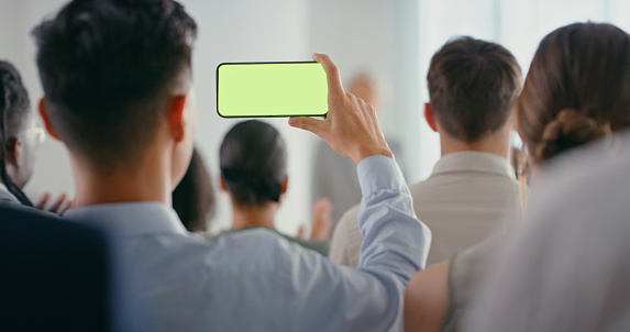 Mockup, green screen and chroma key with a business man recording a meeting on his phone during a training seminar. Marketing, advertising and space for a logo, brand or product during a conference
