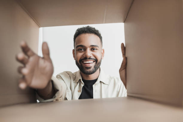 istock Surprised excited man opening parcel. Delivery concept 1423034203