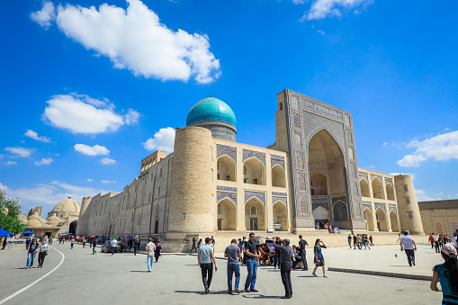 Bukhara, Uzbekistan - May 12, 2022: View to the Medieval Architectural Ensemble Poi Kalyan with Tourists in Bukhara
