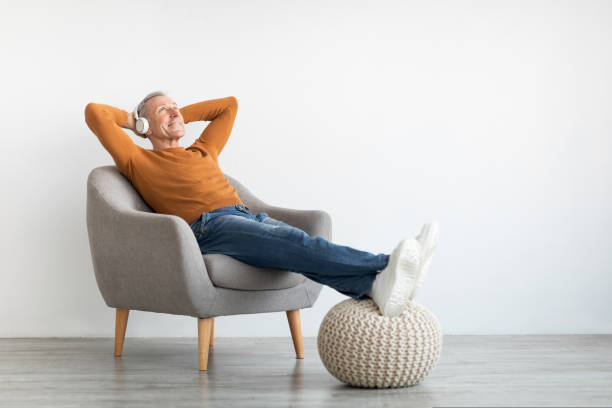 차분한 성숙한 남자 데 휴식 에 집 듣기 에 음악 - mature adult home interior chair contemporary 뉴스 사진 이미지
