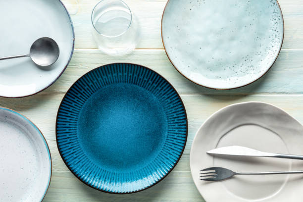 istock Modern tableware set with cutlery and a vibrant blue plate, with a glass 1423042479