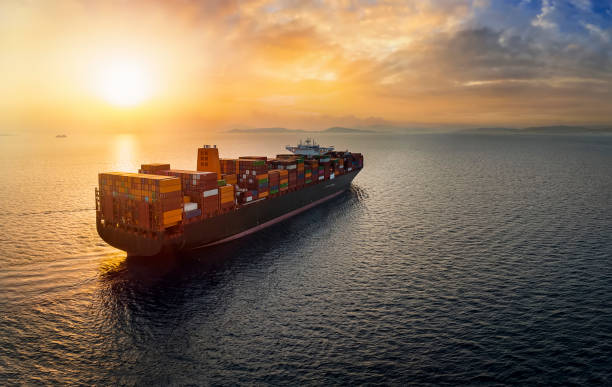Aerial sunset view of a large, heavy loaded container cargo ship