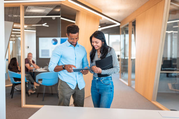 istock Two business colleagues talking in office hallway 1423048156