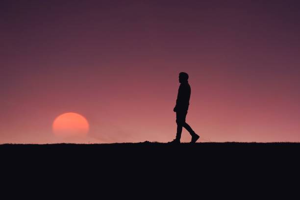 istock man trekking in the countryside with a beautiful sunset background 1423049486