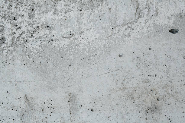istock Partially smooth grey concrete texture riddled with holes from escaping gases 1423053875