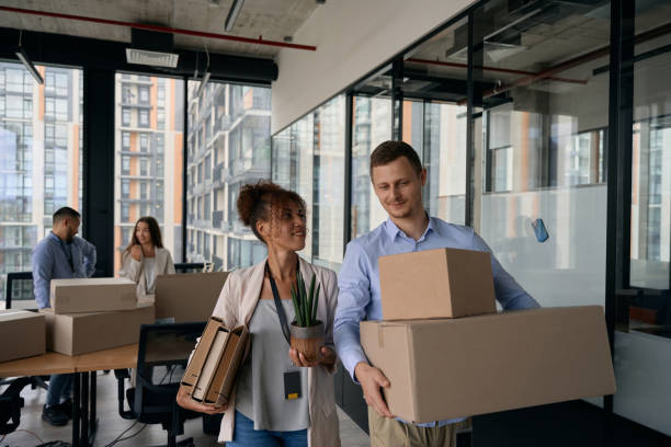 Young company workers packing for office move stock photo