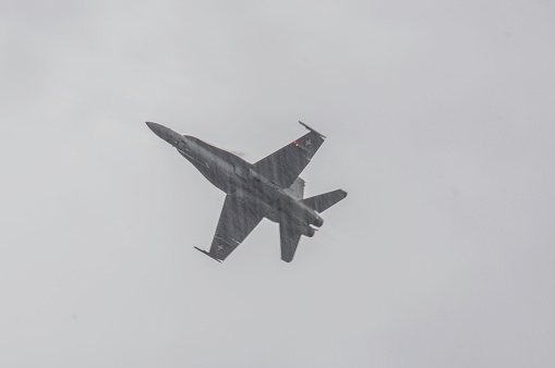 Leopoldsburg, Belgium, - September 10, 2022. People watching a fighter jet at the International Sanicole airshow in the middle of a rain shower.