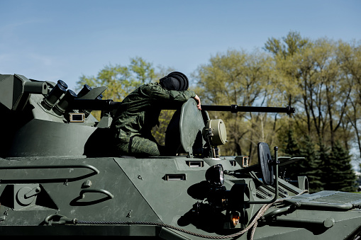 a tired soldier is sitting on a tank. military conflict