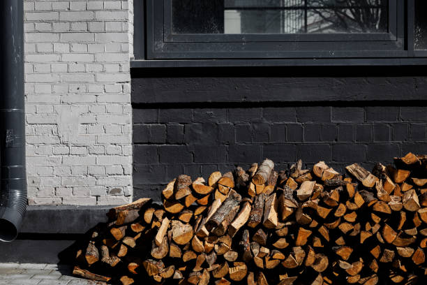 wood logs ready for heating in winter stacked in storage place in a modern brick wall