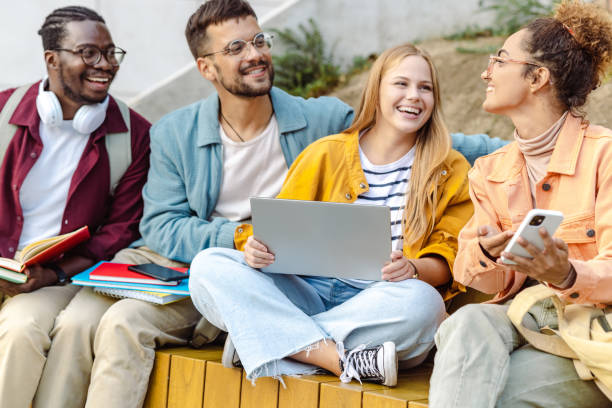 istock Hanging out on campus. Young group of students using laptop 1423063382