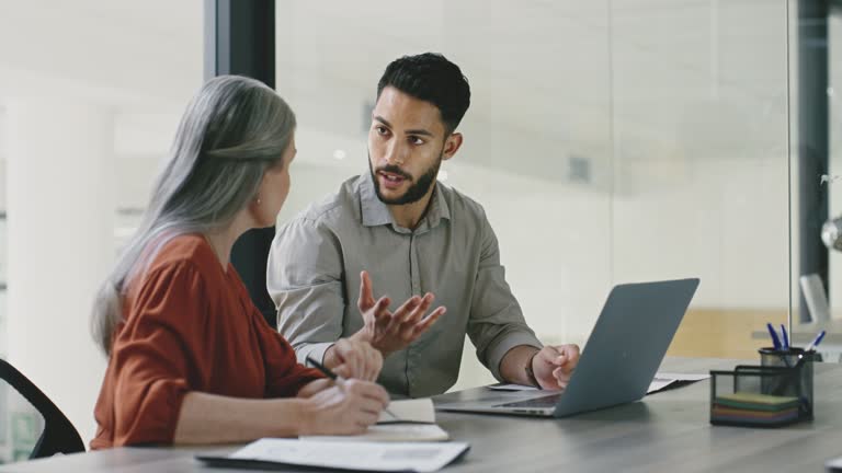 Business meeting, mentor and teamwork with intern man learning and training data analyst, accounting or database management on a laptop. Accountants doing tax compliance audit while talking in office