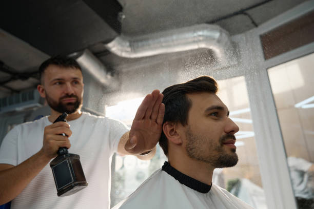 istock Attractive guy having his hair sprayed by a barber 1423070809