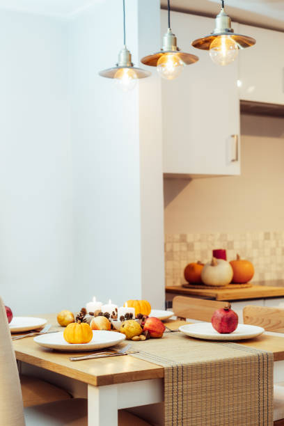 fall table setting for celebration thanksgiving day family party. autumn composition with candles, fruits, nuts and cones. plates with pumpkins and pomegranate. natural autumn decor. selective focus - autumn table setting flower imagens e fotografias de stock