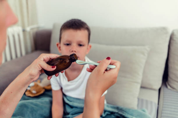 istock Little boy taking a spoon of medicine. 1423078228