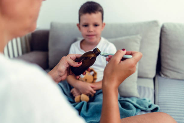 istock Little boy taking a spoon of medicine. 1423079661