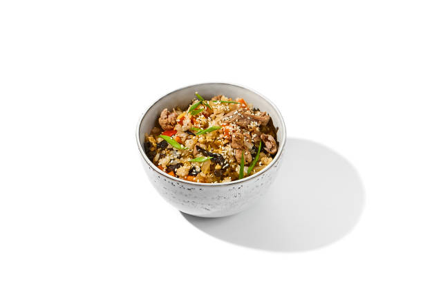 Fried rice with beef and vegetables isolated on white background Traditional chinese food - fried rice with egg and beef in ceramic bowl. Bowl with fried rice, beef and mushrooms Fried rice with beef and vegetables isolated on white background. Traditional chinese food - fried rice with egg and beef in ceramic bowl. Bowl with fried rice, beef and mushrooms chinese cuisine fried rice asian cuisine wok stock pictures, royalty-free photos & images