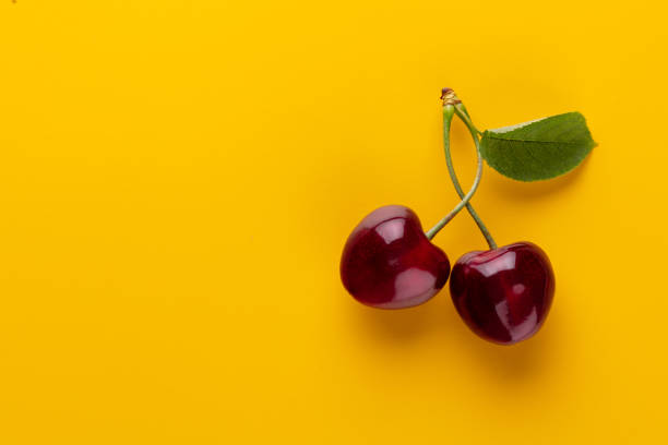istock Cherry berries on a pastel background top view.  Background with a cherry on a sprig, flat lay 1423081070