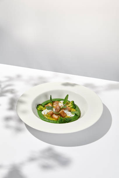 istock Creative dish from roasted chicken and broccoli puree on white plate. Sliced baked chicken with vegetables and creamy espuma in summer menu. 1423081166
