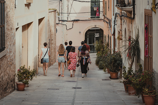 Alcudia, Spain - Aug 26, 2022: Street view with tourists walking in central part of old town Alcudia, Mallorca, Spain.