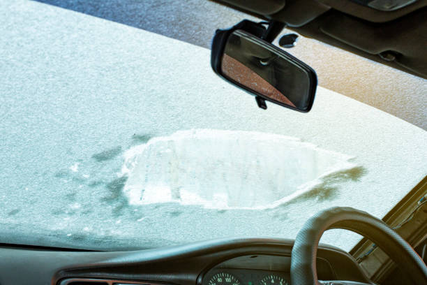 istock powdered car with the first snow, the problem of cleaning the windshield with wipers in the cold. Front and back background blurred with bokeh effect 1423085475
