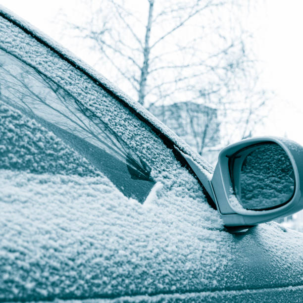 istock powdered car with the first snow, the problem of cleaning the windshield with wipers in the cold. Front and back background blurred with bokeh effect 1423085579