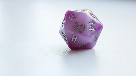 Violet D20 Dungeons & Dragons dice on white background. Natural 20. Concept of good luck.