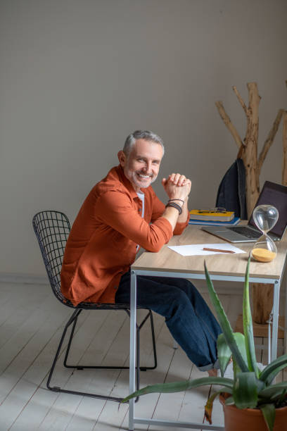 istock A man sitting at the table in the offcie and looking contented 1423093565