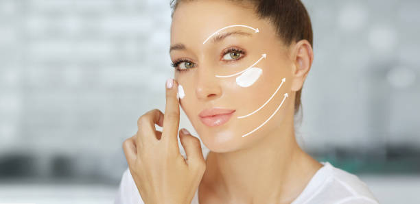 istock woman applying serum, lotion to her face 1423093727