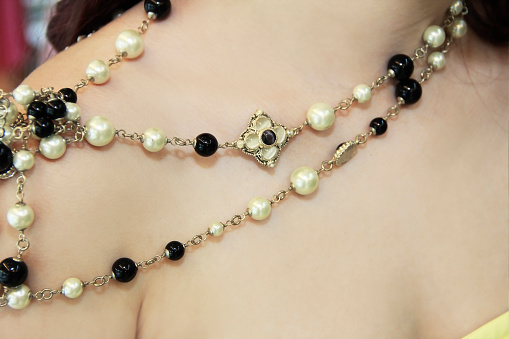women's jewelry necklace on the neck made of round beads of white and black a pearls