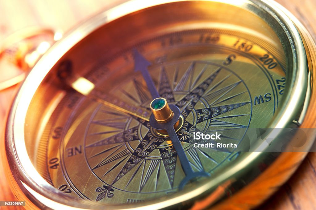 Close-up of a golden compass showing direction Golden compass Navigational Compass Stock Photo