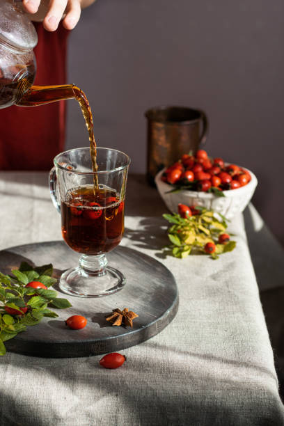 istock female hand pours hot herbal tea into a glass mug. Vertical 1423100549