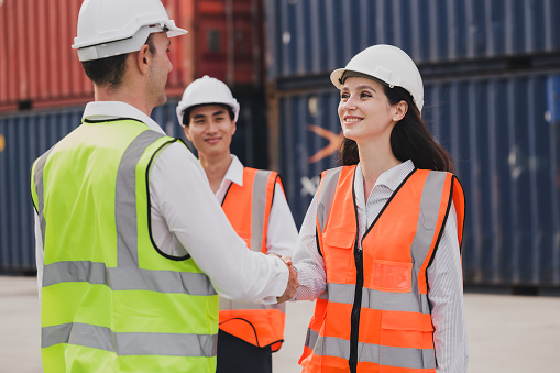 Caucasian business managers and worker team is meeting do shake hands on a large commercial tracking inventory, close up. Business Partnership Greeting Handshaking to seal the deal After Discussion.
