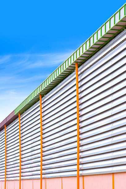istock Perspective side view of aluminum louver with gutter drainage system of warehouse building against blue sky 1423110632
