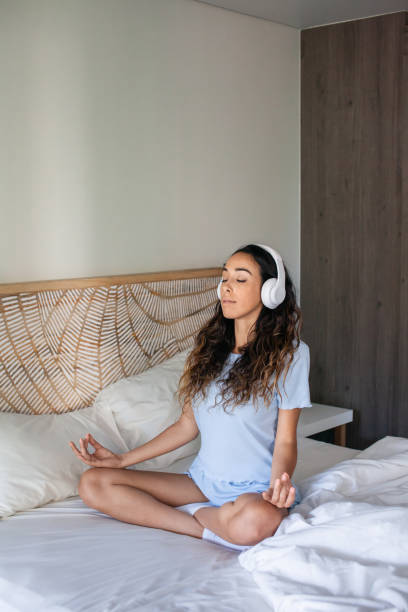 istock Tranquil woman meditating in bed 1423115581