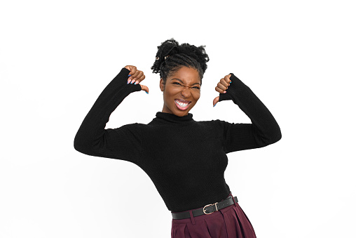 Portrait of proud African American woman. Female model in turtleneck with curly hair looking at camera, gesturing. Portrait, studio shot, emotion concept