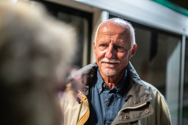 Senior man talking to wife on the subway platform