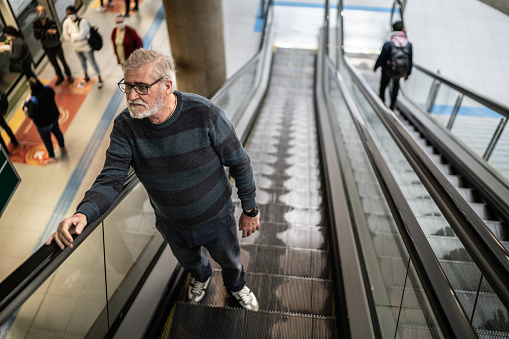 Senior man on the escalator in the subway station