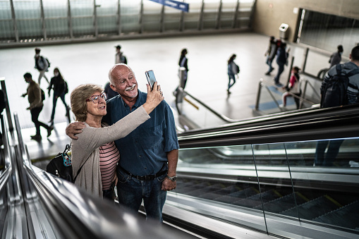 Senior couple on a video call using mobile phone in a subway station