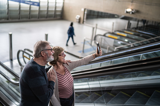 Senior couple on a video call using mobile phone in a subway station