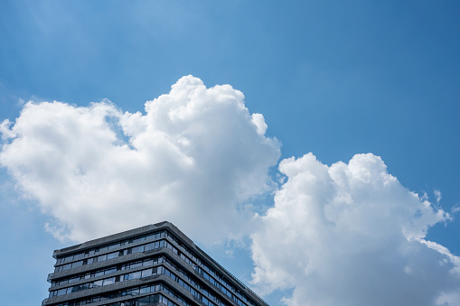 Facades of modern buildings under blue sky and white clouds